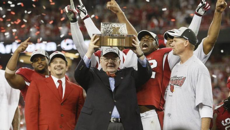 Arizona Cardinals owner, Bill Bidwill, flanked by Arizona Cardinals president Michael Bidwill, left, and head coach Ken Whisenhunt, holds the NFC Championship trophy after beating the Philadelphia Eagles Sunday, Jan. 18, 2009, at the University of Phoenix Stadium in Glendale.

NFC Championship Game  - Arizona Cardinals vs Philadelphia Eagles - Q4 - Bidwills, Ken Whisenhunt