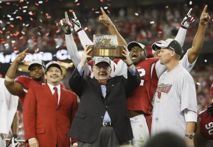 Arizona Cardinals owner, Bill Bidwill, flanked by Arizona Cardinals president Michael Bidwill, left, and head coach Ken Whisenhunt, holds the NFC Championship trophy after beating the Philadelphia Eagles Sunday, Jan. 18, 2009, at the University of Phoenix Stadium in Glendale.

NFC Championship Game  - Arizona Cardinals vs Philadelphia Eagles - Q4 - Bidwills, Ken Whisenhunt