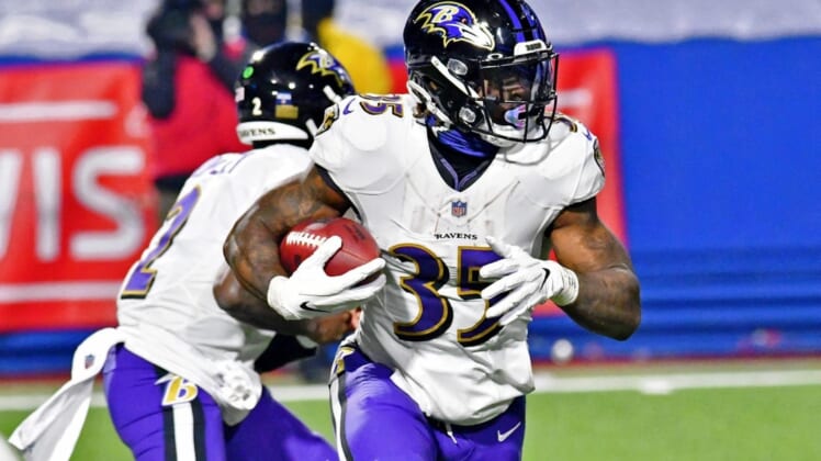 Jan 16, 2021; Orchard Park, New York, USA; Baltimore Ravens running back Gus Edwards (35) runs with the ball against the Buffalo Bills during the second half of an AFC Divisional Round playoff game at Bills Stadium. The Buffalo Bills won 17-3. Mandatory Credit: Mark Konezny-USA TODAY Sports