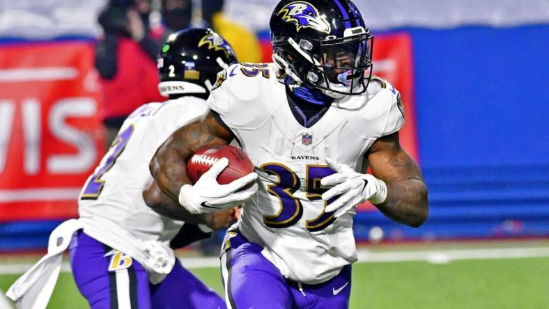 Jan 16, 2021; Orchard Park, New York, USA; Baltimore Ravens running back Gus Edwards (35) runs with the ball against the Buffalo Bills during the second half of an AFC Divisional Round playoff game at Bills Stadium. The Buffalo Bills won 17-3. Mandatory Credit: Mark Konezny-USA TODAY Sports