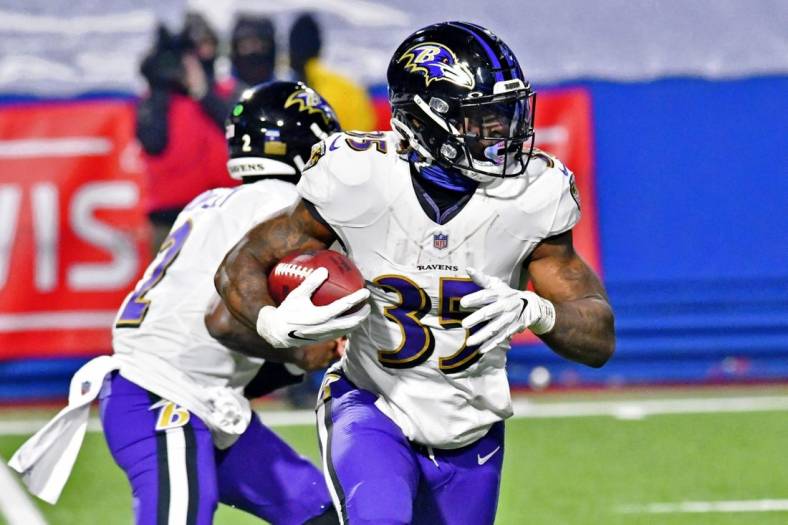 Jan 16, 2021; Orchard Park, New York, USA; Baltimore Ravens running back Gus Edwards (35) runs with the ball against the Buffalo Bills during the second half of an AFC Divisional Round playoff game at Bills Stadium. The Buffalo Bills won 17-3. Mandatory Credit: Mark Konezny-USA TODAY Sports