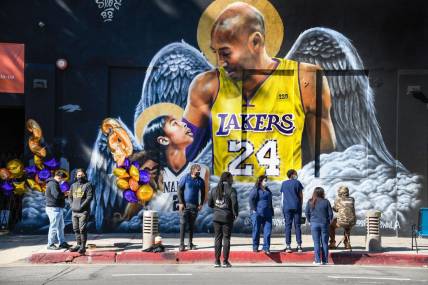 Jan 26, 2021; Los Angeles, California, USA; Fans gather at a mural of Kobe Bryant and his daughter Gianna painted on the wall of Hardcore Fitness Bootcamp gym in downtown Los Angeles. Bryant and his daughter and seven other persons died in a helicopter crash in Calabasas, Calif. on Jan. 26, 2020. Mandatory Credit: Robert Hanashiro-USA TODAY Sports