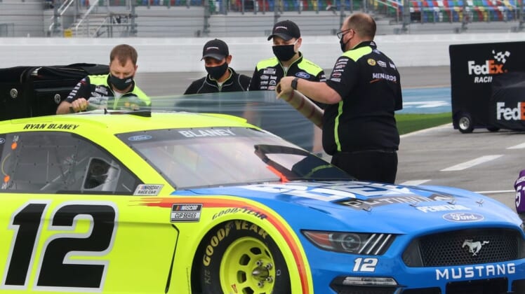 Crewmen seal up Ryan Blaney's Ford with clingy plastic wrap before putting the car cover on, Sunday morning February 14, 2021 as rain treatens the Daytona 500.Dtb Daytona 500 1