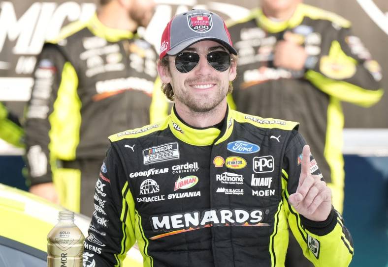 Aug 22, 2021; Brooklyn, Michigan, USA; NASCAR Cup Series driver Ryan Blaney (12) poses with the trophy after winning the FireKeepers Casino 400 at Michigan International Speedway. Mandatory Credit: Mike Dinovo-USA TODAY Sports
