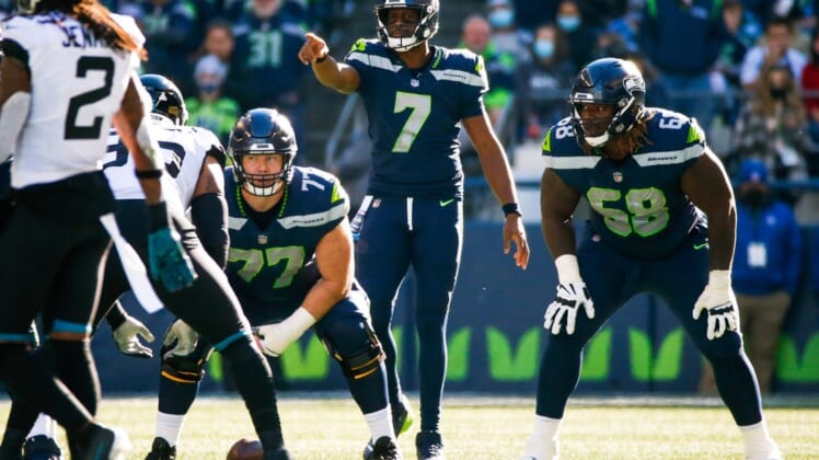 Oct 31, 2021; Seattle, Washington, USA; Seattle Seahawks quarterback Geno Smith (7) signals as center Ethan Pocic (77) and guard Damien Lewis (68) wait for the snap against the Jacksonville Jaguars during the second quarter at Lumen Field. Mandatory Credit: Joe Nicholson-USA TODAY Sports