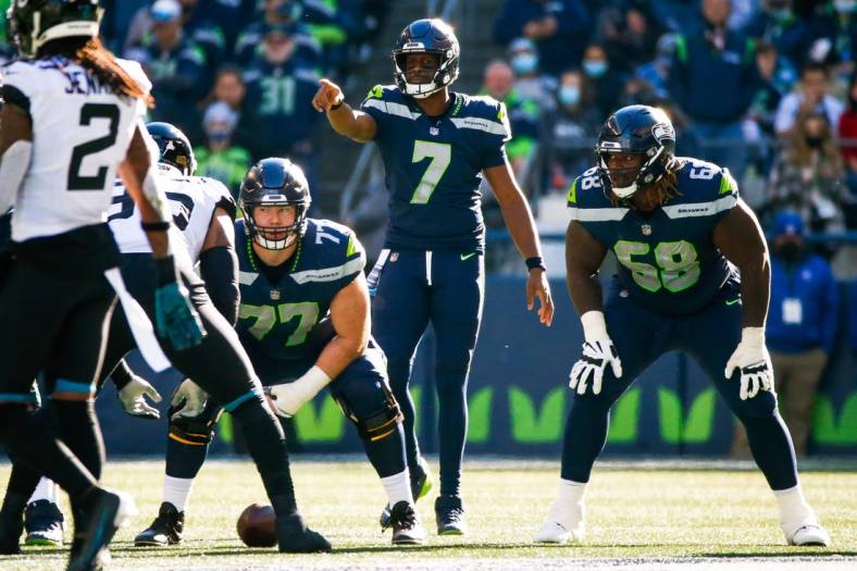 Oct 31, 2021; Seattle, Washington, USA; Seattle Seahawks quarterback Geno Smith (7) signals as center Ethan Pocic (77) and guard Damien Lewis (68) wait for the snap against the Jacksonville Jaguars during the second quarter at Lumen Field. Mandatory Credit: Joe Nicholson-USA TODAY Sports