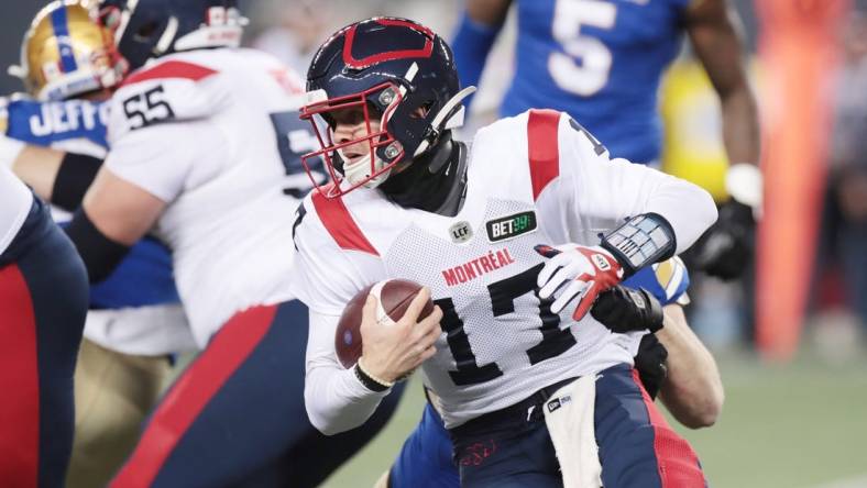 Nov 6, 2021; Winnipeg, Manitoba, CAN; Montreal Alouettes quarterback Trevor Harris (17) is tackled from behind during a Canadian football League game at IG Field. Mandatory Credit: Bruce Fedyck-USA TODAY Sports