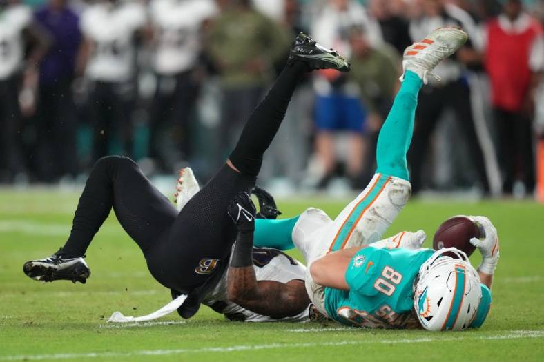 Nov 11, 2021; Miami Gardens, Florida, USA; Miami Dolphins tight end Adam Shaheen (80) comes down with a catch while being defended by Baltimore Ravens safety Chuck Clark (36) during the first half at Hard Rock Stadium. Mandatory Credit: Jasen Vinlove-USA TODAY Sports