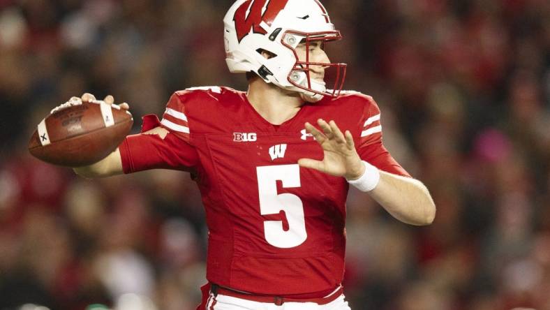 Nov 20, 2021; Madison, Wisconsin, USA;  Wisconsin Badgers quarterback Graham Mertz (5) throws a pass during the third quarter against the Nebraska Cornhuskers at Camp Randall Stadium. Mandatory Credit: Jeff Hanisch-USA TODAY Sports