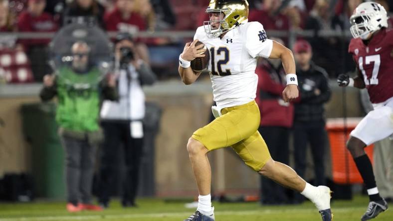 Nov 27, 2021; Stanford, California, USA; Notre Dame Fighting Irish quarterback Tyler Buchner (12) rushes for a touchdown during the fourth quarter against the Stanford Cardinal at Stanford Stadium. Mandatory Credit: Darren Yamashita-USA TODAY Sports