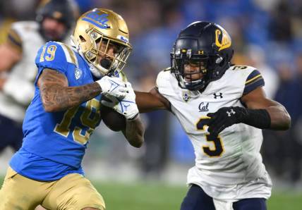 Nov 27, 2021; Pasadena, California, USA;   UCLA Bruins running back Kazmeir Allen (19) is stopped by California Golden Bears safety Elijah Hicks (3) just short of the goal line after a pass reception in the second half at the Rose Bowl. Mandatory Credit: Jayne Kamin-Oncea-USA TODAY Sports