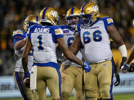 Dec 12, 2021; Hamilton, Ontario, CAN; Winnipeg Blue Bombers offensive lineman Stanley Bryant (66) and offensive lineman Drew Desjarlais (61) congratulate wide receiver Darvin Adams (1) after scoring a touchdown in overtime against the Hamilton Tiger-Cats in the 108th Grey Cup football game at Tim Hortons Field. Mandatory Credit: John E. Sokolowski-USA TODAY Sports