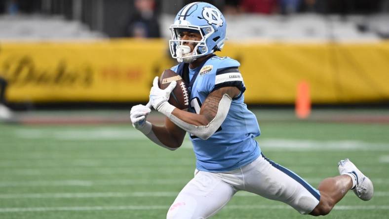 Dec 30, 2021; Charlotte, NC, USA; North Carolina Tar Heels wide receiver Josh Downs (11) catches the ball in the second quarter during the 2021 Duke's Mayo Bowl at Bank of America Stadium. Mandatory Credit: Bob Donnan-USA TODAY Sports