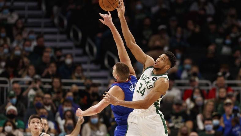 Jan 30, 2022; Milwaukee, Wisconsin, USA;  Milwaukee Bucks forward Giannis Antetokounmpo (34) and Denver Nuggets center Nikola Jokic (15) reach for the ball during the first quarter at Fiserv Forum. Mandatory Credit: Jeff Hanisch-USA TODAY Sports