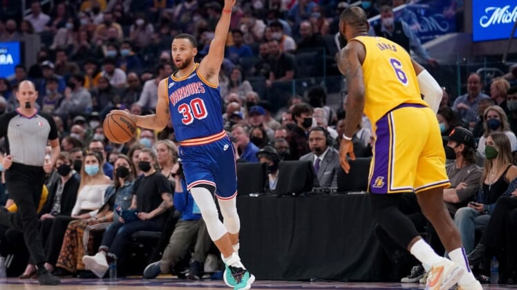 Feb 12, 2022; San Francisco, California, USA; Golden State Warriors guard Stephen Curry (30) calls a play next to Los Angeles Lakers forward LeBron James (6) in the first quarter at the Chase Center. Mandatory Credit: Cary Edmondson-USA TODAY Sports