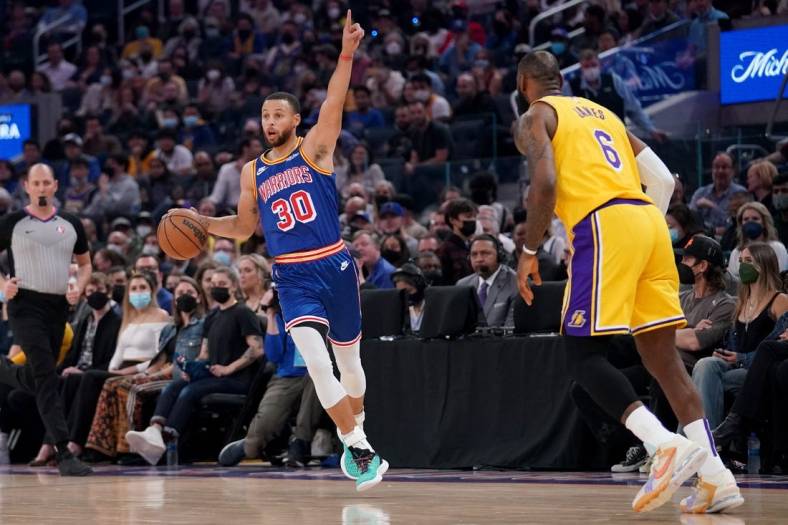 Feb 12, 2022; San Francisco, California, USA; Golden State Warriors guard Stephen Curry (30) calls a play next to Los Angeles Lakers forward LeBron James (6) in the first quarter at the Chase Center. Mandatory Credit: Cary Edmondson-USA TODAY Sports