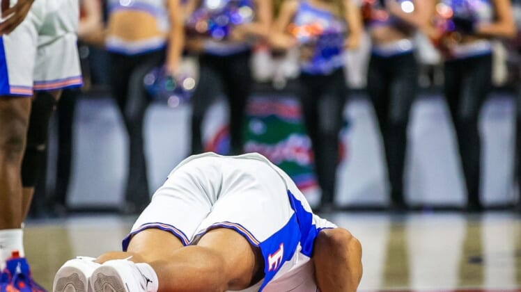 Florida Gators forward Keyontae Johnson (11) kisses the Gator logo after ceremonially starting the game Saturday. Johnson fainted during a game last year and took a one lump sum of $5 million insurance payout. The Kentucky Wildcats lead 38-26 at the half over the Florida Gators Saturday afternoon, March 5, 2022 at the Stephen C. O'Connell Center in Gainesville, FL. [Doug Engle/Ocala Star Banner]2022Gai Uf Kentucky Basketball