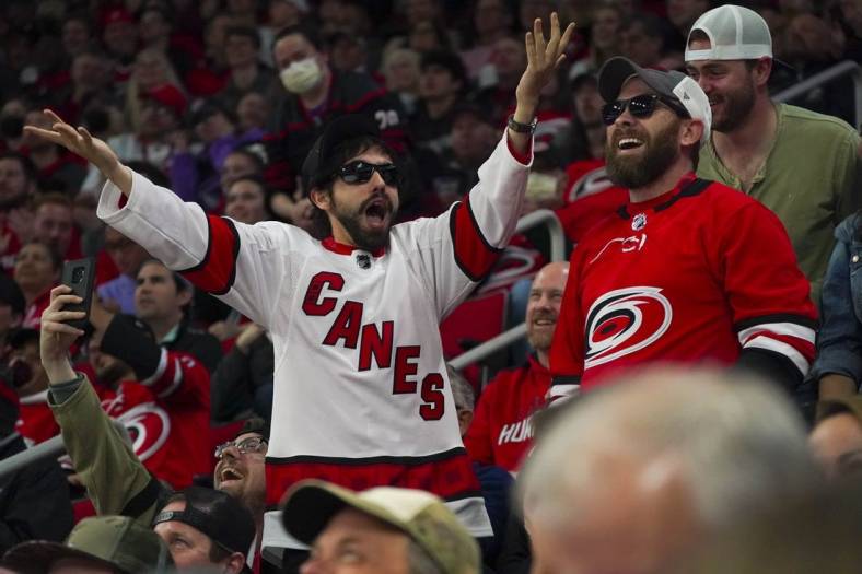 Apr 21, 2022; Raleigh, North Carolina, USA;  Carolina Hurricanes fans celebrate against the Winnipeg Jets during the third period at PNC Arena. Mandatory Credit: James Guillory-USA TODAY Sports