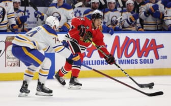 Apr 29, 2022; Buffalo, New York, USA;  Chicago Blackhawks defenseman Caleb Jones (82) makes a pass as Buffalo Sabres center Rasmus Asplund (74) defends during the first period at KeyBank Center. Mandatory Credit: Timothy T. Ludwig-USA TODAY Sports