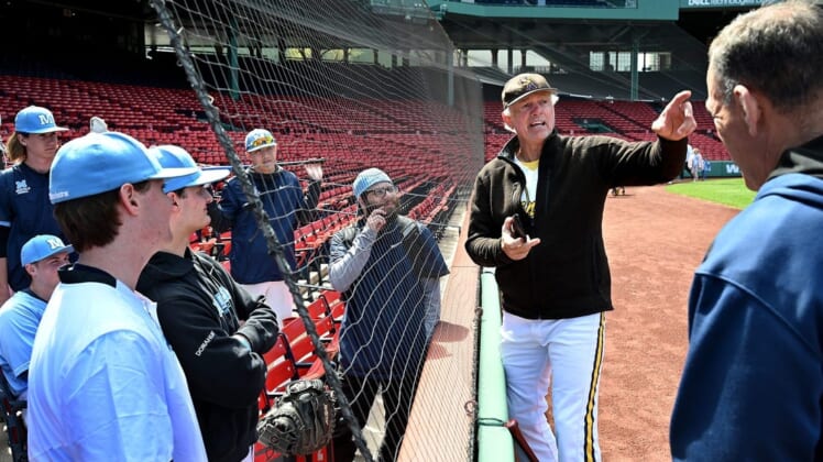 The Medfield baseball team listens to legendary Red Sox pitcher Bill "The Spaceman" Lee before the Fenway Park matchup against Hopkinton,  April 29, 2022. Lee, 75, was in the uniform for his Savannah Bananas travel team.9543113002p Bos Fenway