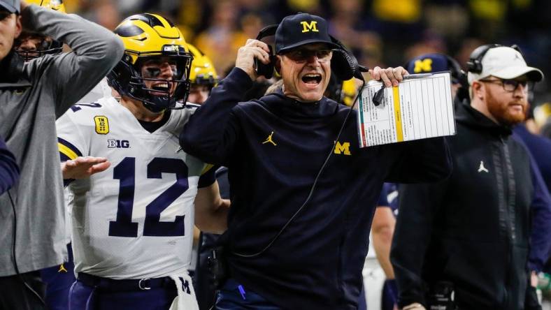 Michigan coach Jim Harbaugh and quarterback Cade McNamara celebrate a touchdown against Iowa during the first half of the Big Ten championship game at Lucas Oil Stadium in Indianapolis on Saturday, Dec. 4, 2021.

Syndication Detroit Free Press