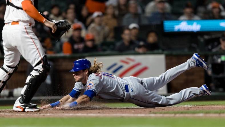 May 24, 2022; San Francisco, California, USA; New York Mets center fielder Travis Jankowski (16) drives home to score against the San Francisco Giants during the ninth inning at Oracle Park. Mandatory Credit: John Hefti-USA TODAY Sports