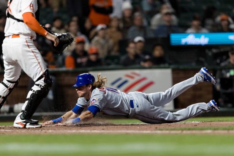 May 24, 2022; San Francisco, California, USA; New York Mets center fielder Travis Jankowski (16) drives home to score against the San Francisco Giants during the ninth inning at Oracle Park. Mandatory Credit: John Hefti-USA TODAY Sports