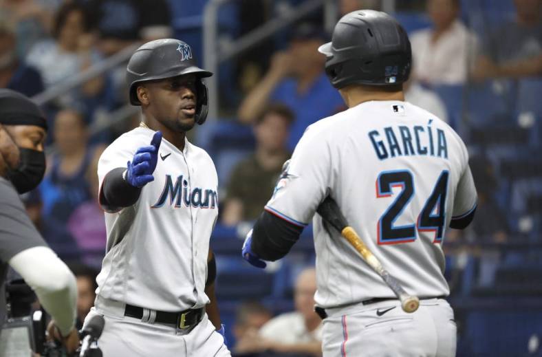 May 25, 2022; St. Petersburg, Florida, USA; Miami Marlins right fielder Jorge Soler (12) is congratulated by right fielder Avisail Garcia (24) as he hits a home run during the fourth inning against the Tampa Bay Rays  at Tropicana Field. Mandatory Credit: Kim Klement-USA TODAY Sports