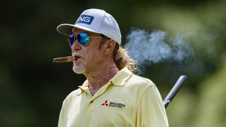 May 29, 2022; Benton Harbor, Michigan, USA; Miguel Angel Jimenez walks off the tee box while smoking a cigar on the thirteenth hole during the final round of the 2022 KitchenAid Senior PGA Championship at Harbor Shores. Mandatory Credit: Raj Mehta-USA TODAY Sports