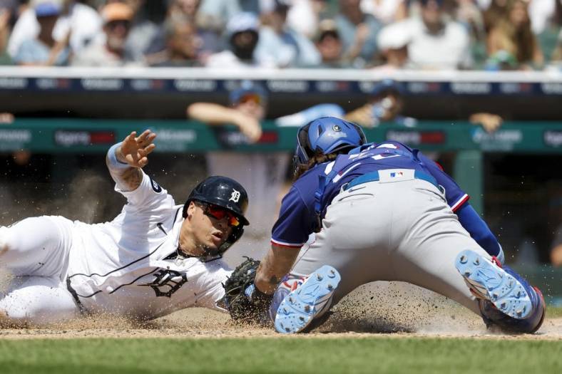 Jun 19, 2022; Detroit, Michigan, USA;  Detroit Tigers shortstop Javier Baez (28) slides in safe at home ahead of the tag by Texas Rangers catcher Jonah Heim (28) in the fifth inning at Comerica Park. Mandatory Credit: Rick Osentoski-USA TODAY Sports