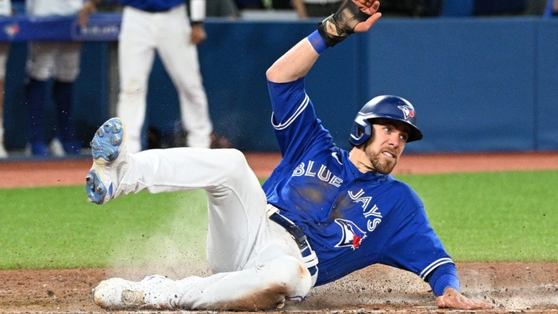 Jun 28, 2022; Toronto, Ontario, CAN;  Toronto Blue Jays pinch runner Bradley Zimmer (7) slides across home plate after scoring against the Boston Red Sox in the ninth inning at Rogers Centre. Mandatory Credit: Dan Hamilton-USA TODAY Sports
