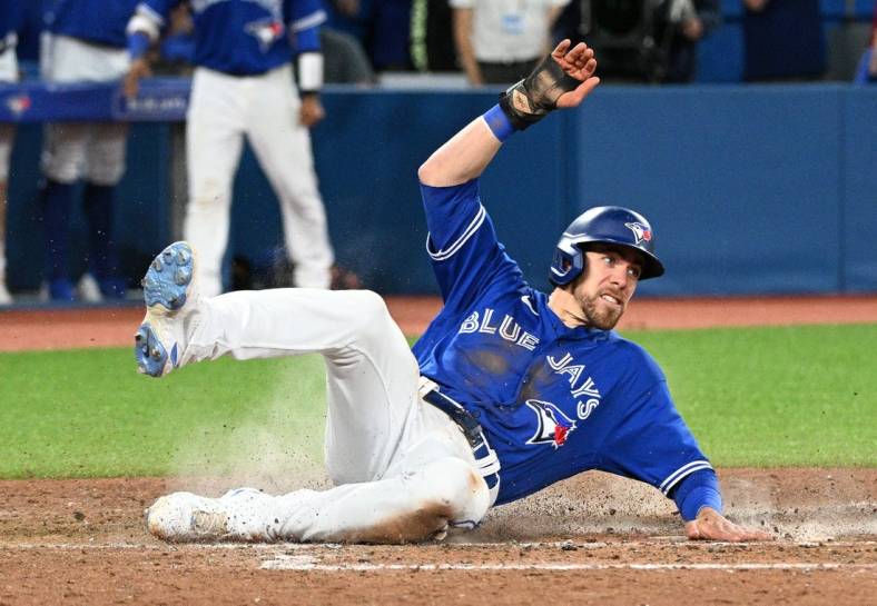 Jun 28, 2022; Toronto, Ontario, CAN;  Toronto Blue Jays pinch runner Bradley Zimmer (7) slides across home plate after scoring against the Boston Red Sox in the ninth inning at Rogers Centre. Mandatory Credit: Dan Hamilton-USA TODAY Sports
