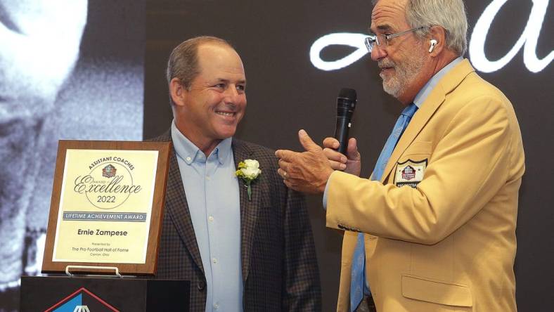 Ken Zampese ,left, accepts the Pro Football Hall of Fame Assistant Coaches Award of Excellence for his father Ernie Zampese from master of ceremonies Hall of Famer Dan Fouts at the Pro Football Hall of Fame Thursday, June 30, 2022.

Ssh36241