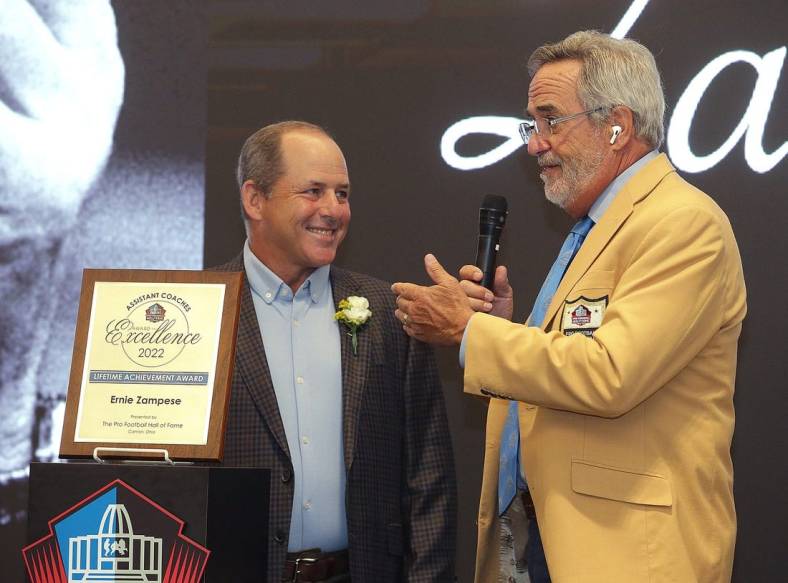 Ken Zampese ,left, accepts the Pro Football Hall of Fame Assistant Coaches Award of Excellence for his father Ernie Zampese from master of ceremonies Hall of Famer Dan Fouts at the Pro Football Hall of Fame Thursday, June 30, 2022.

Ssh36241