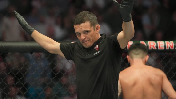 Jul 2, 2022; Las Vegas, Nevada, USA; Ring referee Jason Herzog waves off the fight after Pedro Munhoz (red gloves) was accidentally poked in the eye during the bout against Sean O'Malley (blue gloves) during UFC 276 at T-Mobile Arena. Mandatory Credit: Stephen R. Sylvanie-USA TODAY Sports