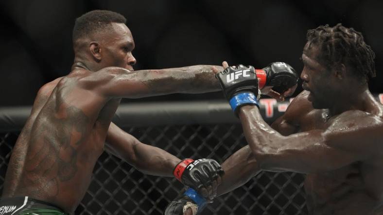 Jul 2, 2022; Las Vegas, Nevada, USA; Israel Adesanya (red gloves) and Jared Cannonier (blue gloves) fight in a bout during UFC 276 at T-Mobile Arena. Mandatory Credit: Stephen R. Sylvanie-USA TODAY Sports