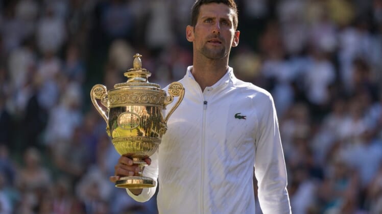 Jul 10, 2022; London, United Kingdom; Novak Djokovic (SRB) poses with the trophy after winning the men   s final against Nick Kyrgios (not pictured) on day 14 at All England Lawn Tennis and Croquet Club. Mandatory Credit: Susan Mullane-USA TODAY Sports