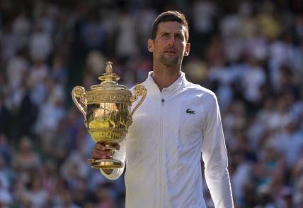 Jul 10, 2022; London, United Kingdom; Novak Djokovic (SRB) poses with the trophy after winning the men   s final against Nick Kyrgios (not pictured) on day 14 at All England Lawn Tennis and Croquet Club. Mandatory Credit: Susan Mullane-USA TODAY Sports