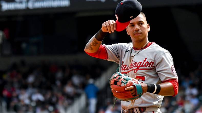 Jul 9, 2022; Cumberland, Georgia, USA; Washington Nationals left fielder Ehire Adrianza (5) readjusts his hat during a game against the Atlanta Braves at Truist Park. Mandatory Credit: Larry Robinson-USA TODAY Sports