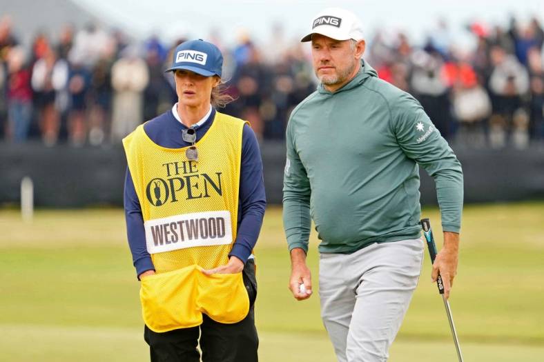 Jul 14, 2022; St. Andrews, SCT; Lee Westwood stands on the 17th green with his wife and caddie Helen Storey during the first round of the 150th Open Championship golf tournament at St. Andrews Old Course. Mandatory Credit: Rob Schumacher-USA TODAY Sports