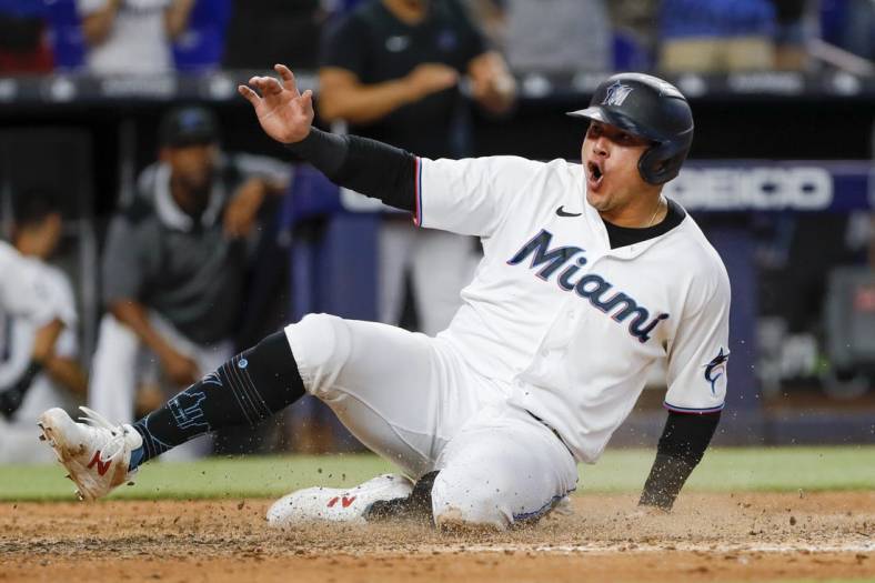Jul 14, 2022; Miami, Florida, USA; Miami Marlins designated hitter Avisail Garcia (24) scores the winning run after a triple by third baseman Brian Anderson (not pictured) during the eleventh inning against the Pittsburgh Pirates at loanDepot Park. Mandatory Credit: Sam Navarro-USA TODAY Sports