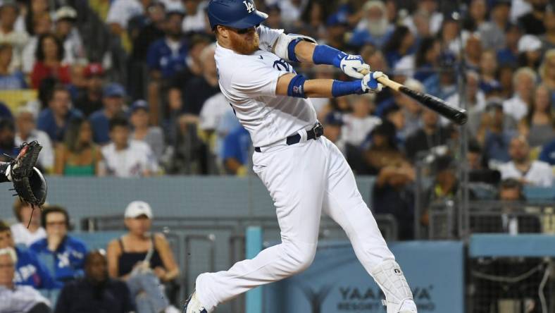 Jul 21, 2022; Los Angeles, California, USA; Los Angeles Dodgers third baseman Justin Turner (10) gets a hit to score two runs in the third inning against the San Francisco Giants at Dodger Stadium. Mandatory Credit: Richard Mackson-USA TODAY Sports