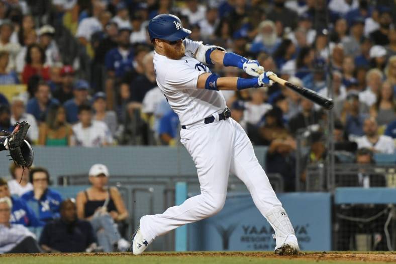 Jul 21, 2022; Los Angeles, California, USA; Los Angeles Dodgers third baseman Justin Turner (10) gets a hit to score two runs in the third inning against the San Francisco Giants at Dodger Stadium. Mandatory Credit: Richard Mackson-USA TODAY Sports