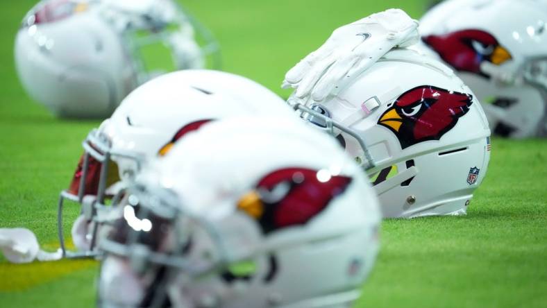 Jul 27, 2022; Glendale, AZ, USA; Arizona Cardinals helmets sit on the field during training camp at State Farm Stadium. Mandatory Credit: Joe Camporeale-USA TODAY Sports