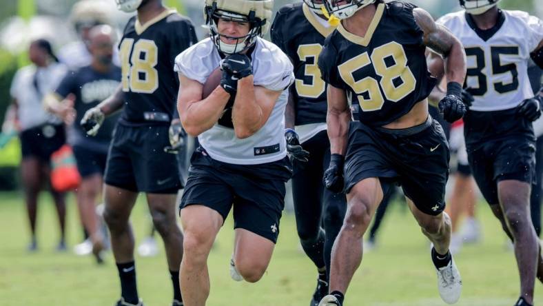 Jul 28, 2022; Metairie, LA, USA;  New Orleans Saints linebacker Eric Wilson (58) attempts to punch the ball from quarterback Taysom Hill (7) during training camp at Ochsner Sports Performance Center. Mandatory Credit: Stephen Lew-USA TODAY Sports