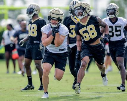 Jul 28, 2022; Metairie, LA, USA;  New Orleans Saints linebacker Eric Wilson (58) attempts to punch the ball from quarterback Taysom Hill (7) during training camp at Ochsner Sports Performance Center. Mandatory Credit: Stephen Lew-USA TODAY Sports
