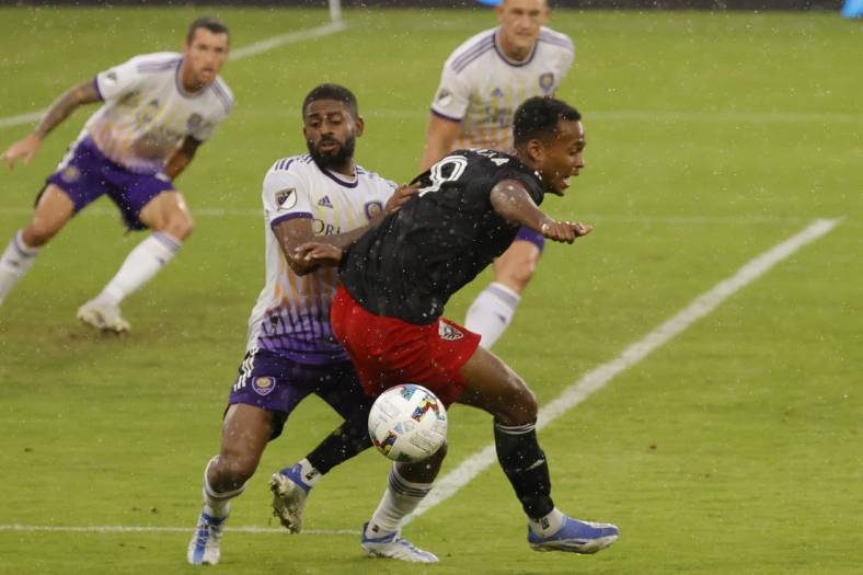 Jul 31, 2022; Washington, District of Columbia, USA; D.C. United forward Ola Kamara (9) is grabbed by Orlando City SC defender Ruan (2) while battling for the ball in the second half at Audi Field. Mandatory Credit: Geoff Burke-USA TODAY Sports