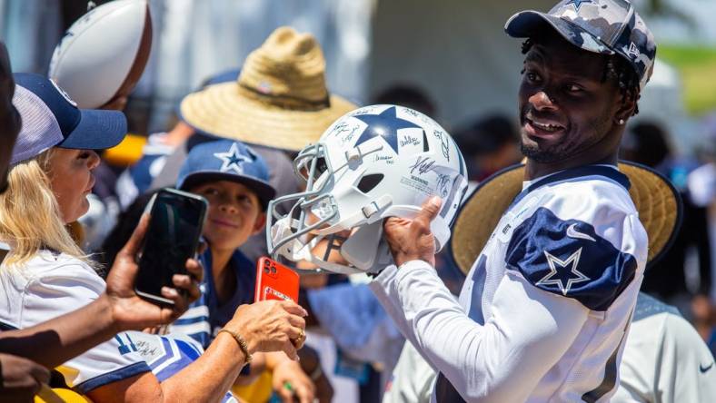 Aug 2, 2022; Oxnard, CA, USA; Dallas Cowboys wide receiver Michael Gallup (13) signs autographs during training camp at River Ridge Playing Fields in Oxnard, California. Mandatory Credit: Jason Parkhurst-USA TODAY Sports