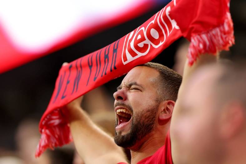 Aug 2, 2022; Harrison, New Jersey, USA; A New York Red Bulls fan holds a scarf and cheers during the national anthem before the game between the Red Bulls and the Colorado Rapids at Red Bull Arena. Mandatory Credit: Vincent Carchietta-USA TODAY Sports