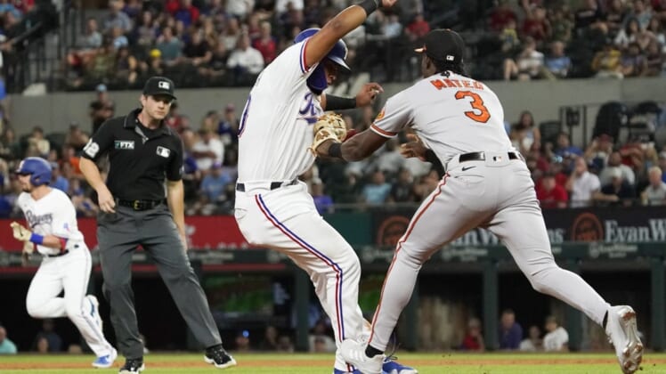 Aug 2, 2022; Arlington, Texas, USA; Texas Rangers catcher Meibrys Viloria (60) is tagged out by Baltimore Orioles shortstop Jorge Mateo (3) after being caught in a run down between second and third base during the second inning at Globe Life Field. Mandatory Credit: Raymond Carlin III-USA TODAY Sports